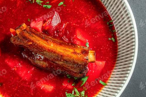 Preview: Traditional beet borscht with braised beef rib served in vibrant red broth close up gourmet presenta