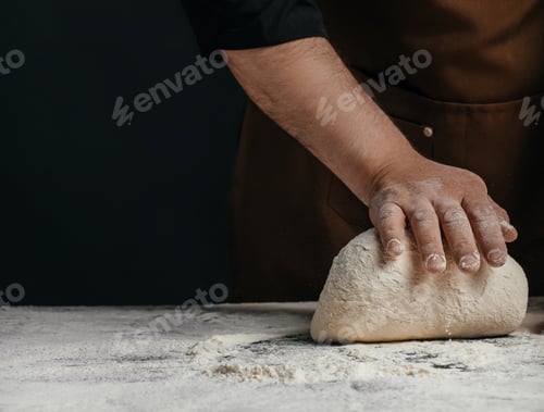Preview: Baker pressing bread dough on floured work surface
