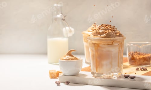 Preview: Whipped dalgona iced coffee with milk and coffee ingredients on bright background