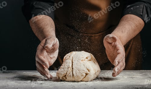 Preview: Baker shaping bread dough with flour dust on worktable
