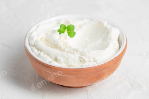 Preview: Fresh cream cheese in rustic bowl with microgreen garnish