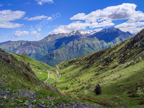 Preview: Scenic view of the Pyrenees mountains with lush green valleys and snow-capped peaks under a bright b