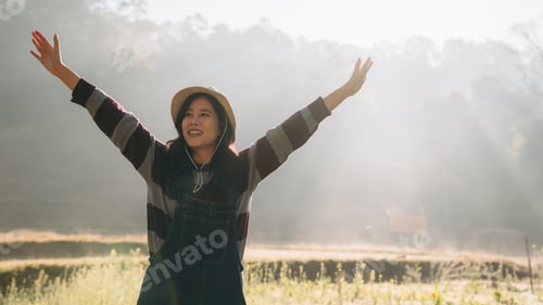 Preview: Happy Young Asian Woman in Straw Hat Holding Coffee Cup and Smiling While Enjoying Peaceful Morning