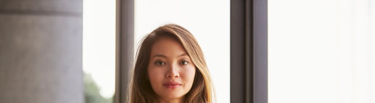 Confident young Asian businesswoman, waist up, close up