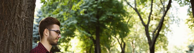 Man sitting on grass with laptop outdoors
