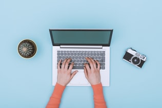 Minimalist light blue workspace with laptop