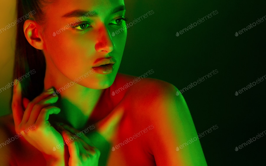Sexy woman posing in neon green and orange lights