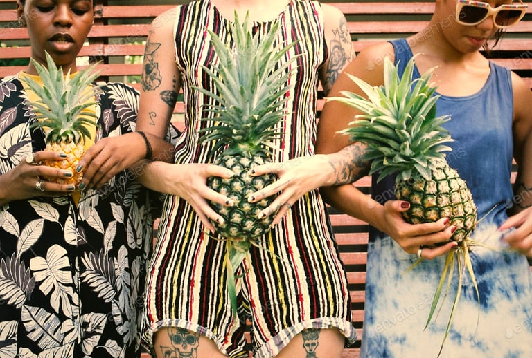 Group of diverse women standing holding pineapple together