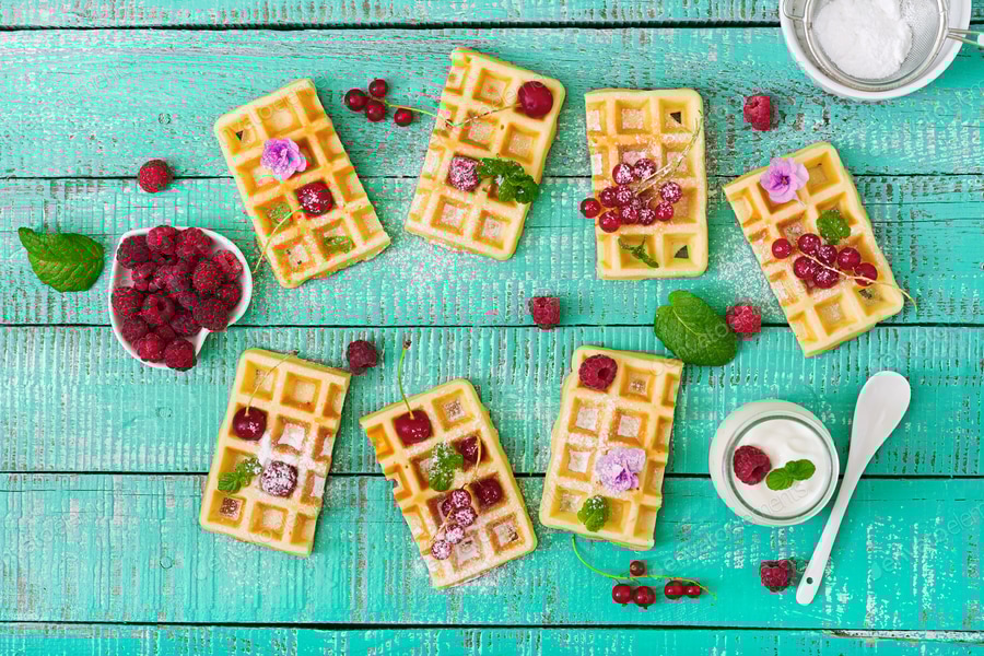 Belgium waffles with raspberries and yogurt on wooden table. Flat lay. Top view