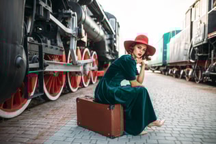 Woman in red hat against vintage steam train