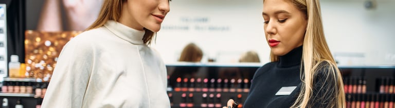 Seller helps woman with choice of eyeshadows