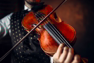 Male violinist playing classical music on violin